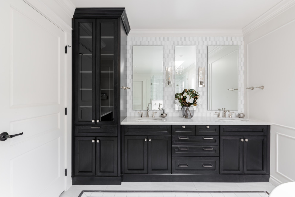 Photo of a large traditional master bathroom in Vancouver with recessed-panel cabinets, black cabinets, a freestanding tub, a corner shower, a one-piece toilet, white tile, porcelain tile, white walls, porcelain floors, an undermount sink, engineered quartz benchtops, white floor, a hinged shower door, white benchtops, an enclosed toilet, a double vanity, a built-in vanity, vaulted and decorative wall panelling.