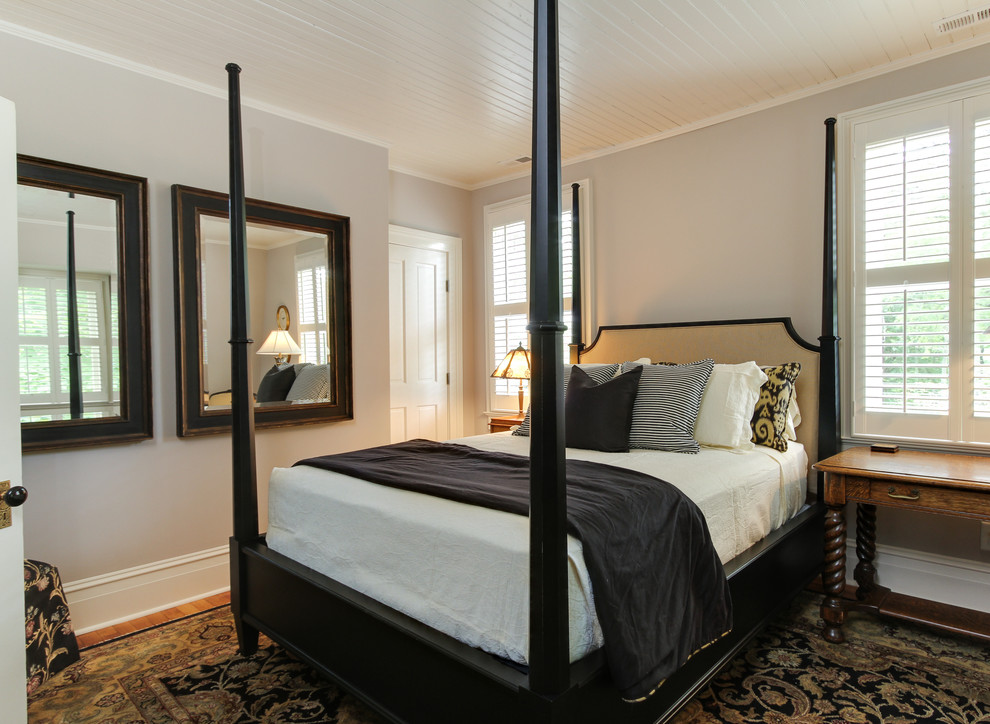 Photo of a mid-sized traditional guest bedroom in Raleigh with grey walls, medium hardwood floors and no fireplace.