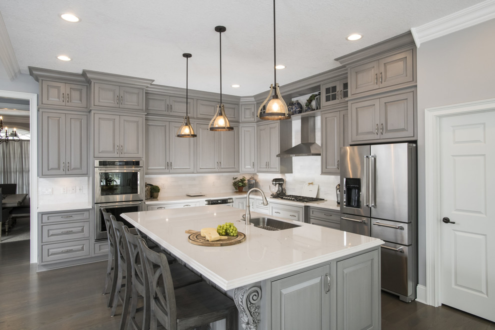 Design ideas for a traditional l-shaped kitchen in Other with an undermount sink, raised-panel cabinets, grey cabinets, marble benchtops, white splashback, marble splashback, stainless steel appliances, with island, dark hardwood floors and brown floor.