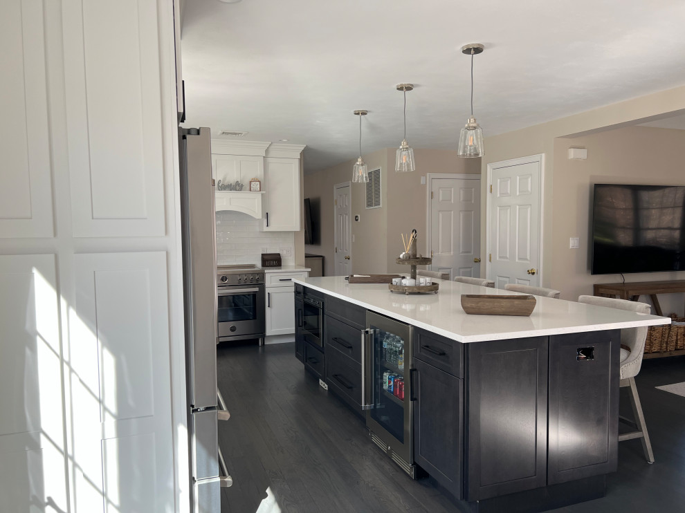Exempel på ett mellanstort klassiskt vit vitt kök, med en undermonterad diskho, skåp i shakerstil, skåp i mörkt trä, bänkskiva i kvarts, vitt stänkskydd, stänkskydd i tunnelbanekakel, rostfria vitvaror, mörkt trägolv, en köksö och grått golv