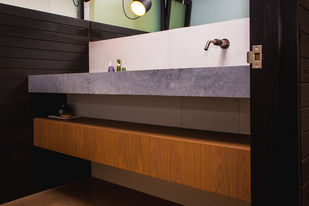 Inspiration for a small modern 3/4 bathroom in Portland with flat-panel cabinets, brown cabinets, concrete benchtops, a single vanity, a floating vanity, black walls, concrete floors, beige floor and grey benchtops.