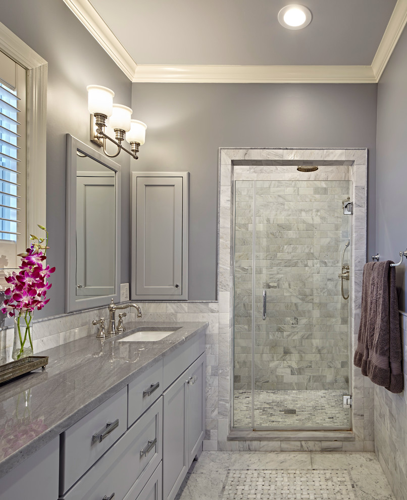 Inspiration for a mid-sized traditional master bathroom in Chicago with an undermount sink, grey cabinets, quartzite benchtops, an alcove shower, gray tile, stone tile, grey walls, mosaic tile floors, recessed-panel cabinets and grey benchtops.