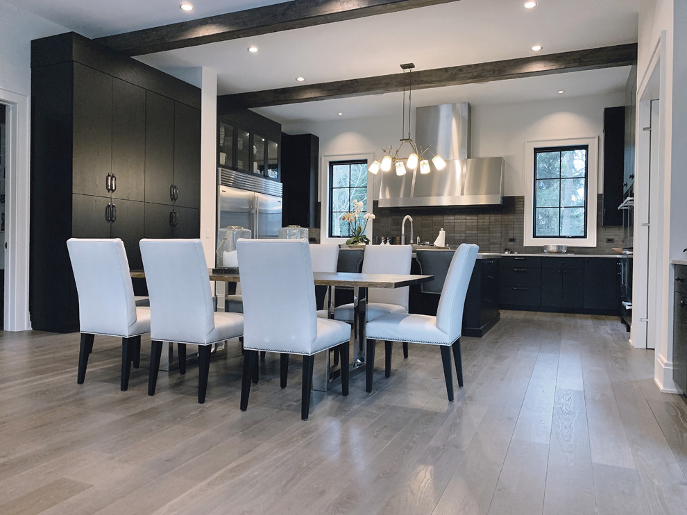Large minimalist u-shaped light wood floor, brown floor and exposed beam eat-in kitchen photo in Chicago with an undermount sink, flat-panel cabinets, black cabinets, wood countertops, multicolored backsplash, mosaic tile backsplash, stainless steel appliances, an island and multicolored countertops