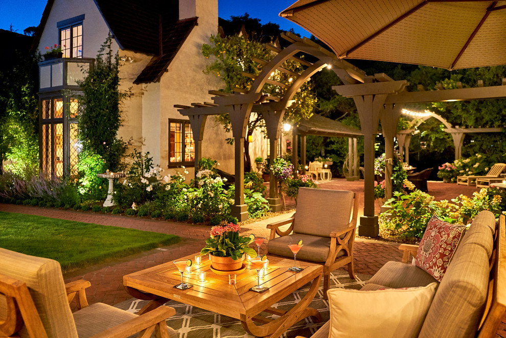 This is an example of an expansive traditional backyard patio in San Francisco with a fire feature, brick pavers and a pergola.