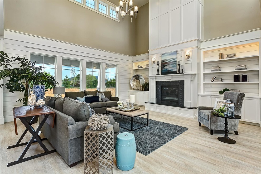 Expansive traditional open concept living room in Boise with beige walls, a standard fireplace, light hardwood floors, no tv and a stone fireplace surround.