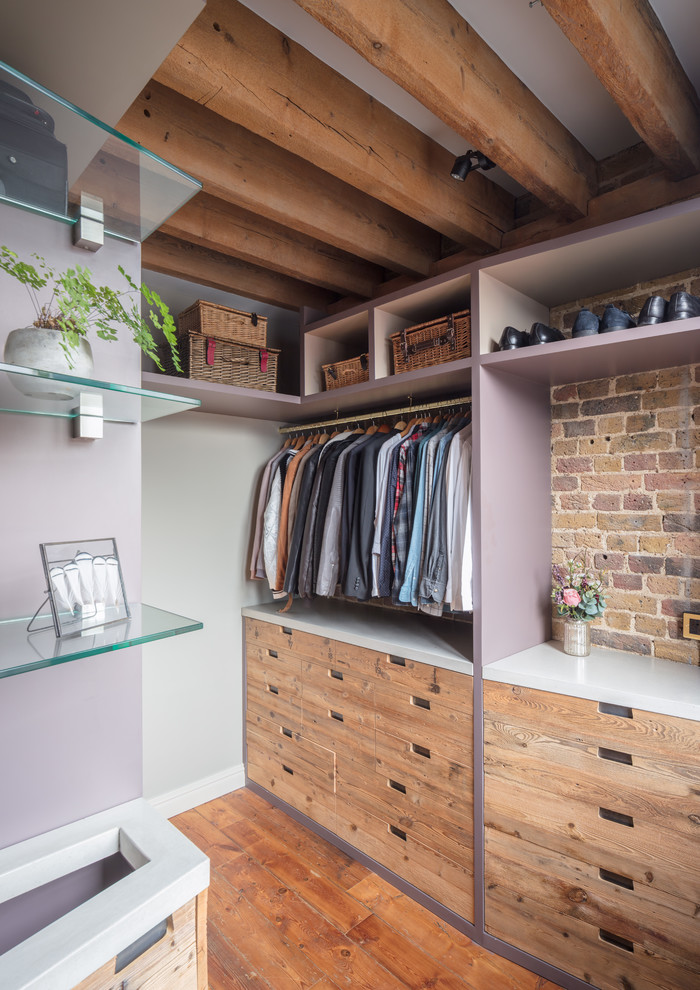 Photo of a large industrial gender-neutral walk-in wardrobe in London with flat-panel cabinets, light wood cabinets, medium hardwood floors and brown floor.