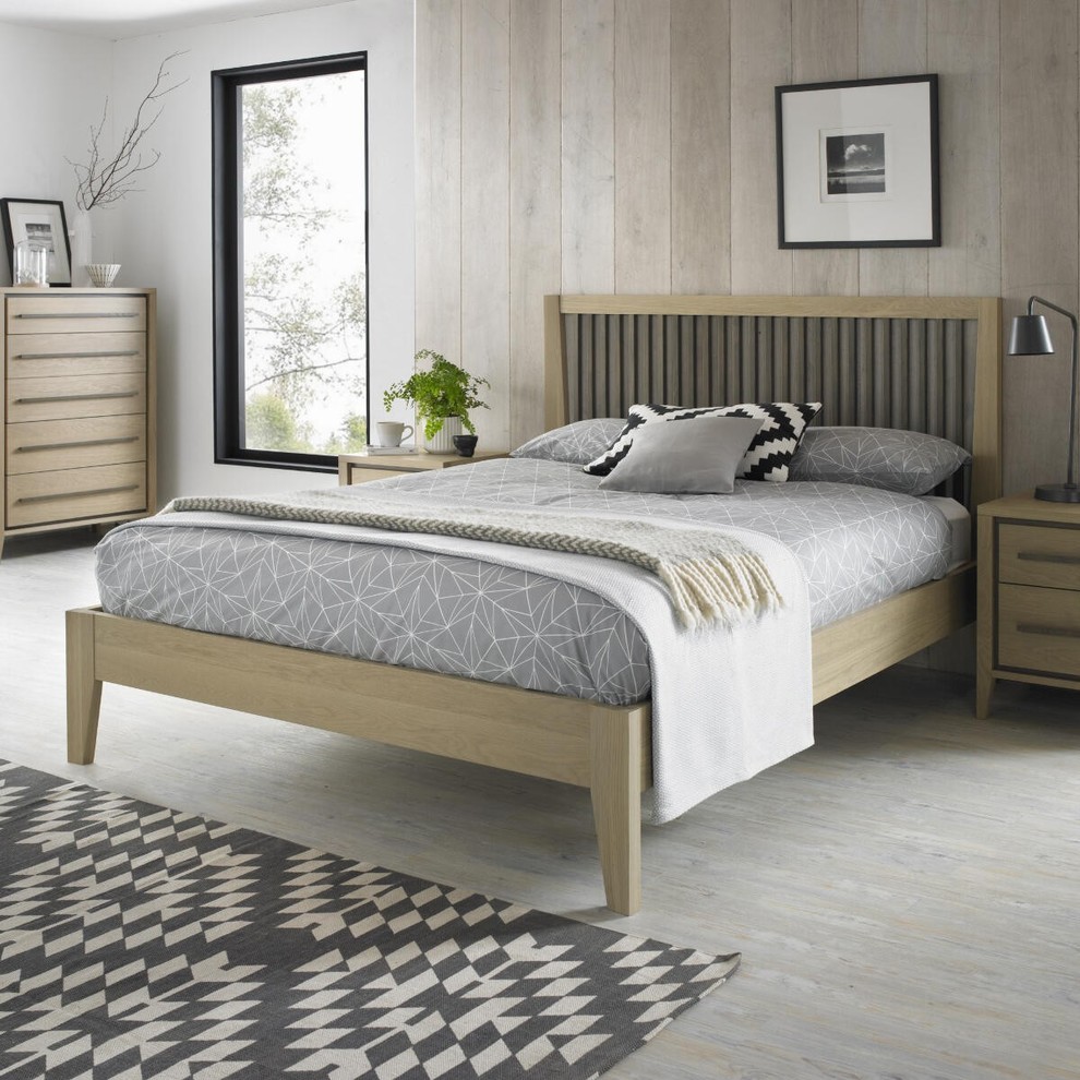 Mid-sized scandinavian guest bedroom in Cork with grey walls, light hardwood floors and grey floor.