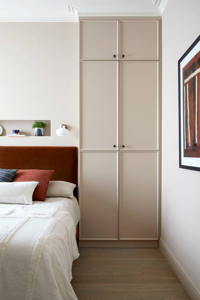 Ejemplo de dormitorio principal moderno de tamaño medio con paredes rosas y suelo de madera clara