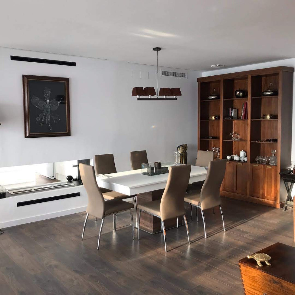 Comedor?[Diseño de comedor With paredes blancas, suelo de madera en tonos medios, chimenea de doble cara, marco de chimenea de metal and suelo marrón ]:[Diseño de comedores With paredes blancas, suelo de madera en tonos medios, chimenea de doble cara, marco de chimenea de metal and suelo marrón ]