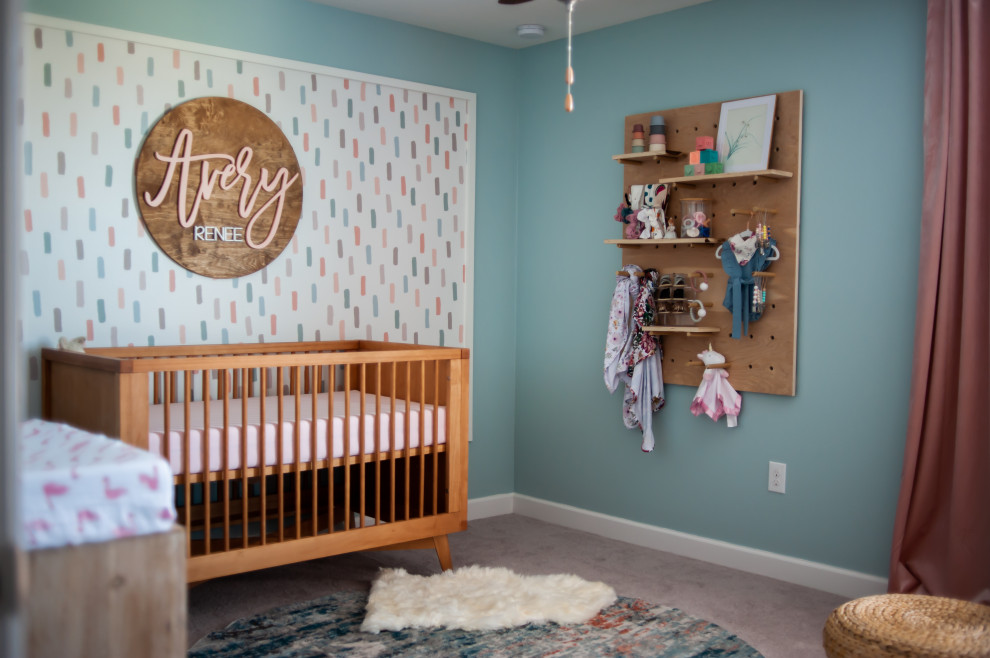 Idee per una cameretta per neonata di medie dimensioni con pareti blu, moquette e pavimento beige