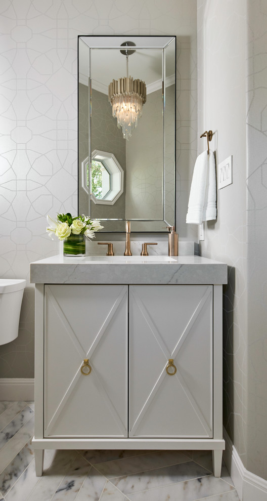Inspiration for a small transitional gray tile marble floor and gray floor powder room remodel in Austin with furniture-like cabinets, white cabinets, gray walls, an undermount sink, quartz countertops, gray countertops and a two-piece toilet