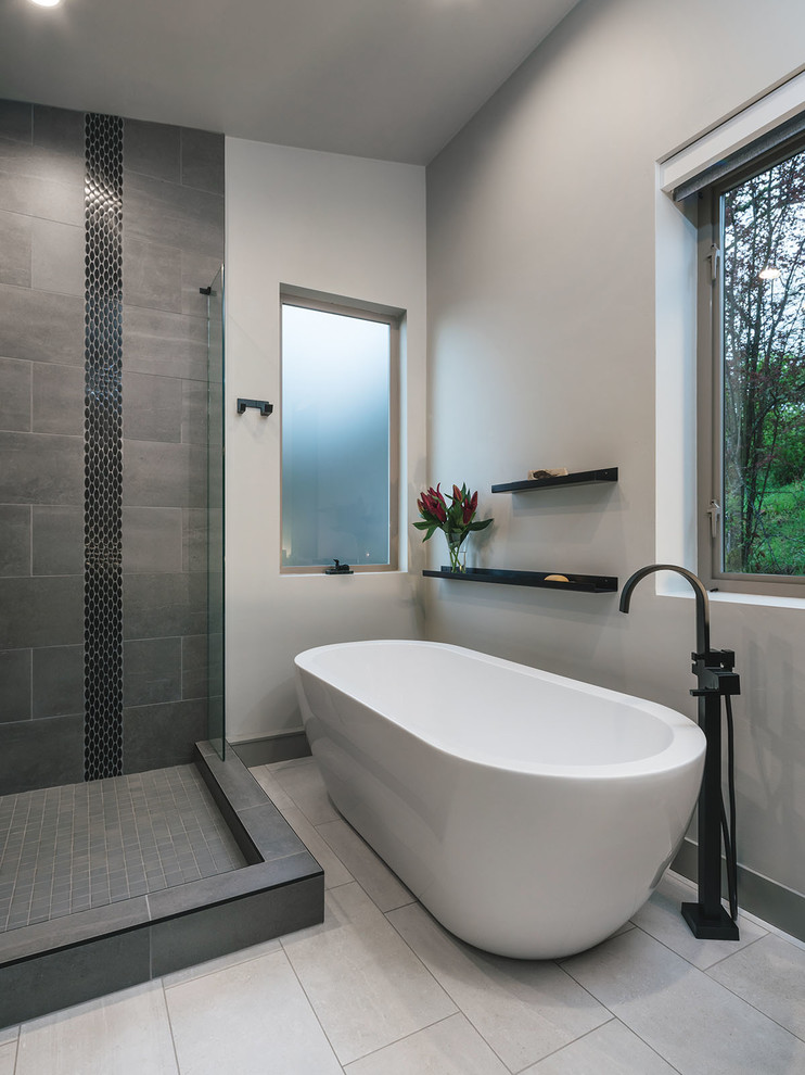 Photo of a large country master bathroom in Portland with shaker cabinets, brown cabinets, a freestanding tub, a corner shower, a one-piece toilet, gray tile, white walls, cement tiles, a drop-in sink, engineered quartz benchtops, a hinged shower door and grey benchtops.