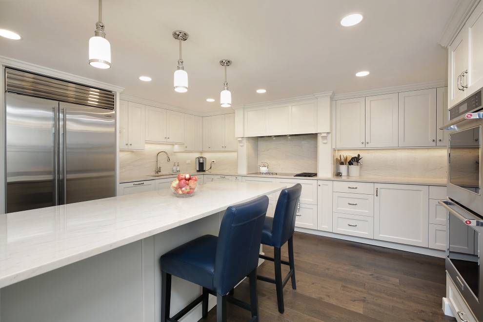 Inspiration for a large classic u-shaped kitchen in Chicago with a submerged sink, shaker cabinets, stainless steel appliances, dark hardwood flooring, a breakfast bar and white worktops.