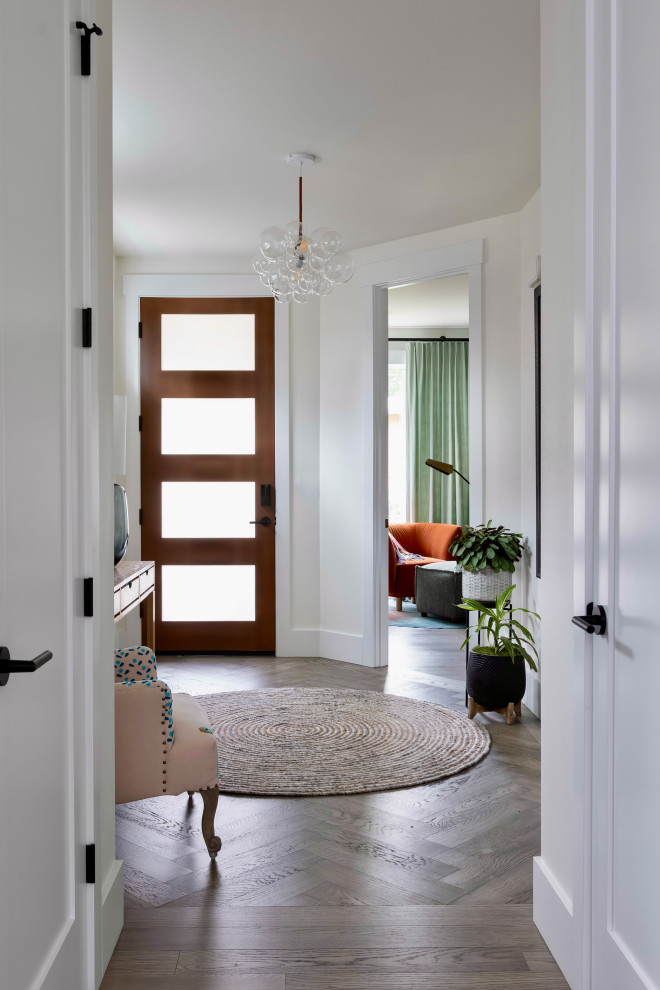 Стильный дизайн: фойе среднего размера в стиле фьюжн с белыми стенами, одностворчатой входной дверью, входной дверью из темного дерева и серым полом - последний тренд