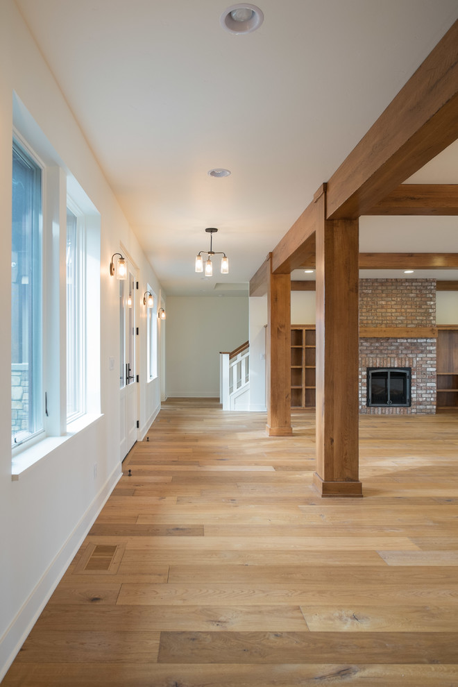 Mid-sized transitional open concept entryway photo with a brick fireplace and a media wall