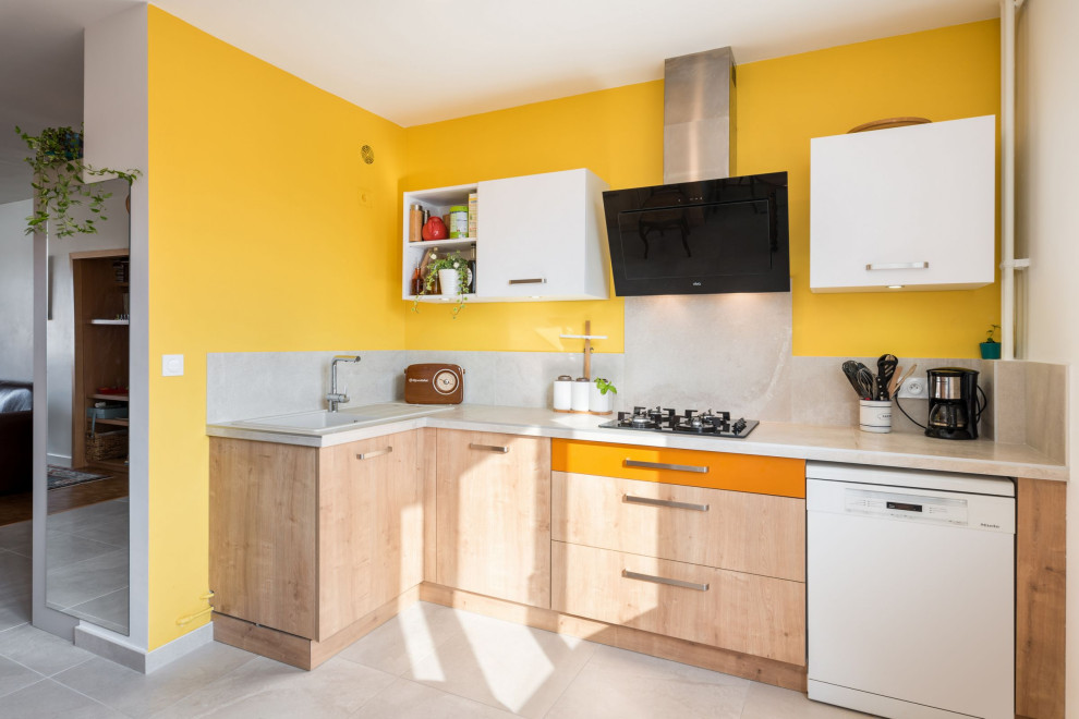 Mid-sized contemporary l-shaped kitchen in Lyon with a drop-in sink, flat-panel cabinets, light wood cabinets, grey splashback, porcelain splashback, panelled appliances and grey benchtop.