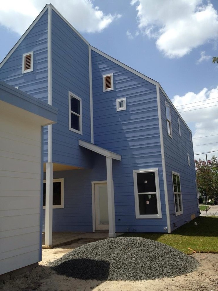 Small contemporary two-storey blue house exterior in Houston with concrete fiberboard siding, a gable roof and a shingle roof.