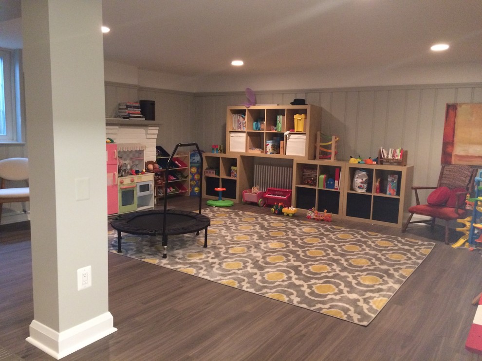 Mid-sized transitional underground laminate floor and brown floor basement photo in Baltimore with gray walls, a standard fireplace and a brick fireplace