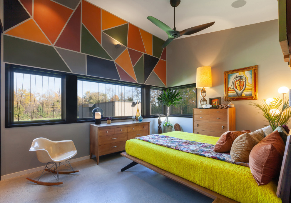 This is an example of a small midcentury master bedroom in Indianapolis with yellow walls, concrete floors, grey floor and vaulted.