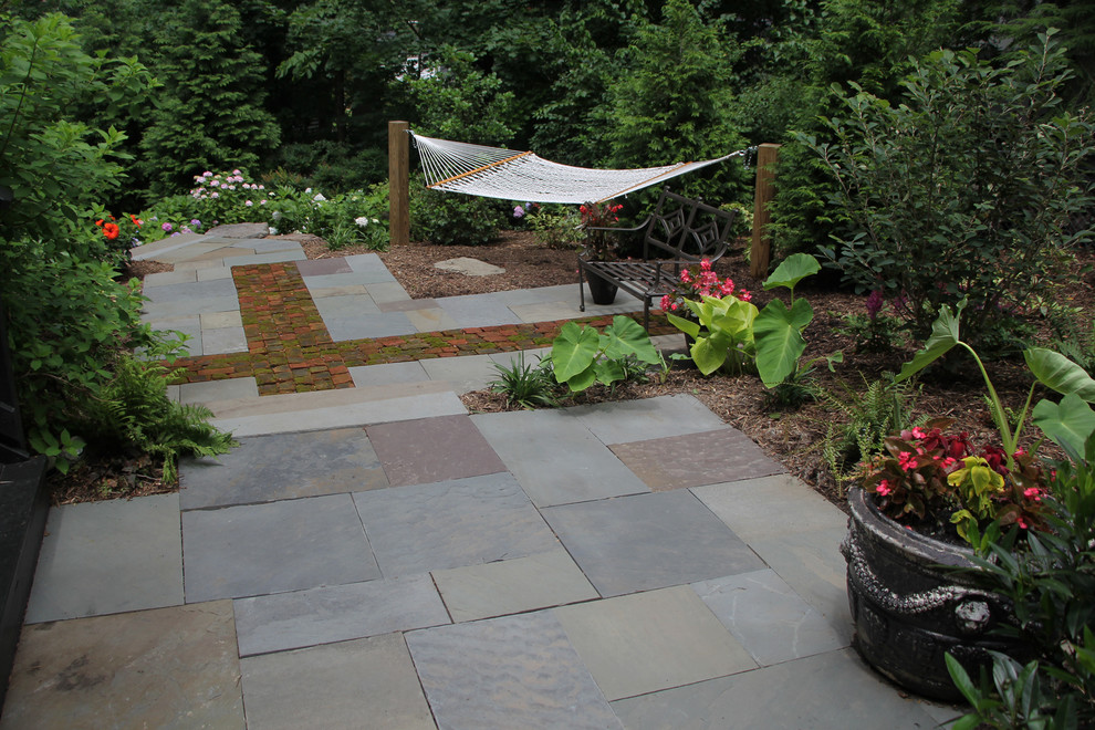 Photo of a contemporary side yard shaded garden for winter in DC Metro with a garden path and natural stone pavers.