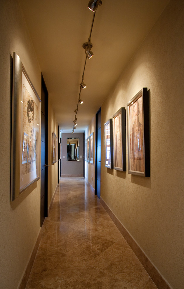 Photo of a mid-sized contemporary hallway in Other with beige walls, marble floors and beige floor.