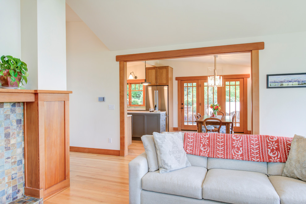 Mid-sized transitional u-shaped medium tone wood floor, brown floor and vaulted ceiling eat-in kitchen photo in Seattle with a double-bowl sink, recessed-panel cabinets, light wood cabinets, quartz countertops, blue backsplash, ceramic backsplash, stainless steel appliances, an island and white countertops