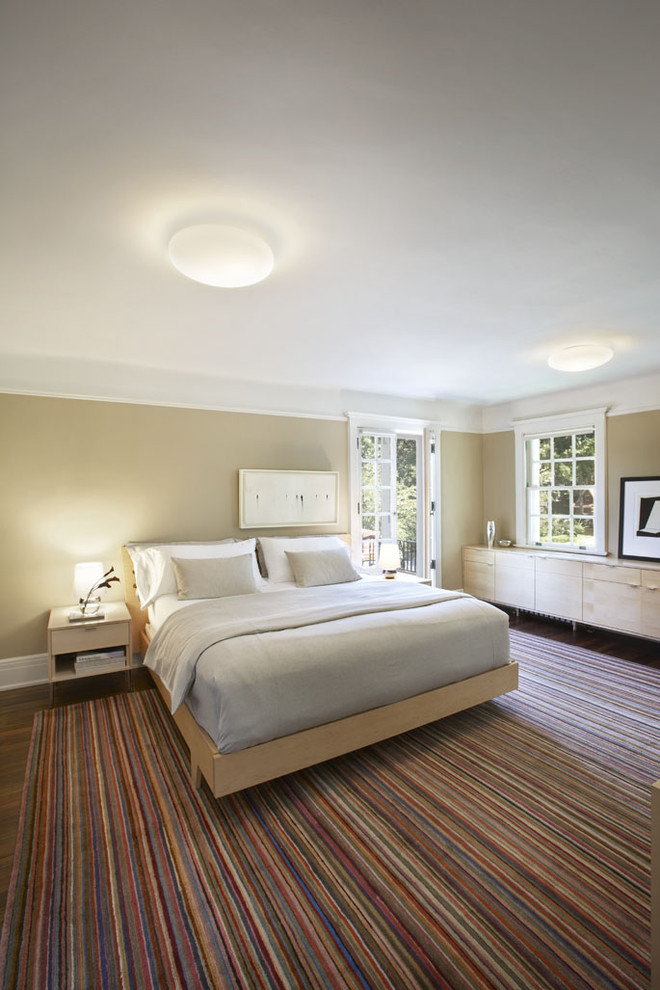 Design ideas for a large modern master bedroom in New York with beige walls and dark hardwood floors.