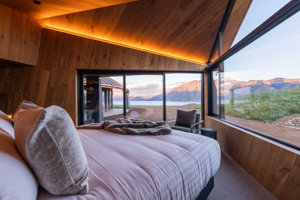 Свежая идея для дизайна: огромная гостевая спальня (комната для гостей) в современном стиле с коричневыми стенами, ковровым покрытием, серым полом, деревянным потолком и панелями на стенах - отличное фото интерьера
