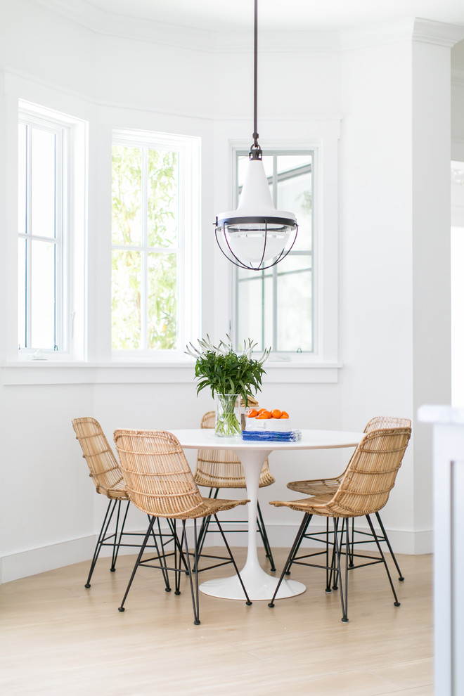 Example of a transitional light wood floor and beige floor dining room design in Orange County with white walls