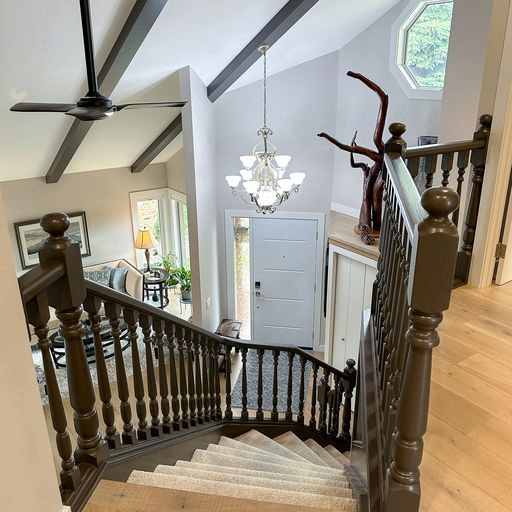 Design ideas for a large traditional carpeted curved wood railing staircase in Calgary with open risers and panelled walls.
