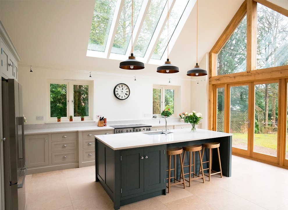 Design ideas for a large traditional l-shaped eat-in kitchen in Surrey with an undermount sink, shaker cabinets, green cabinets, granite benchtops, stainless steel appliances, limestone floors, with island, beige floor and white benchtop.
