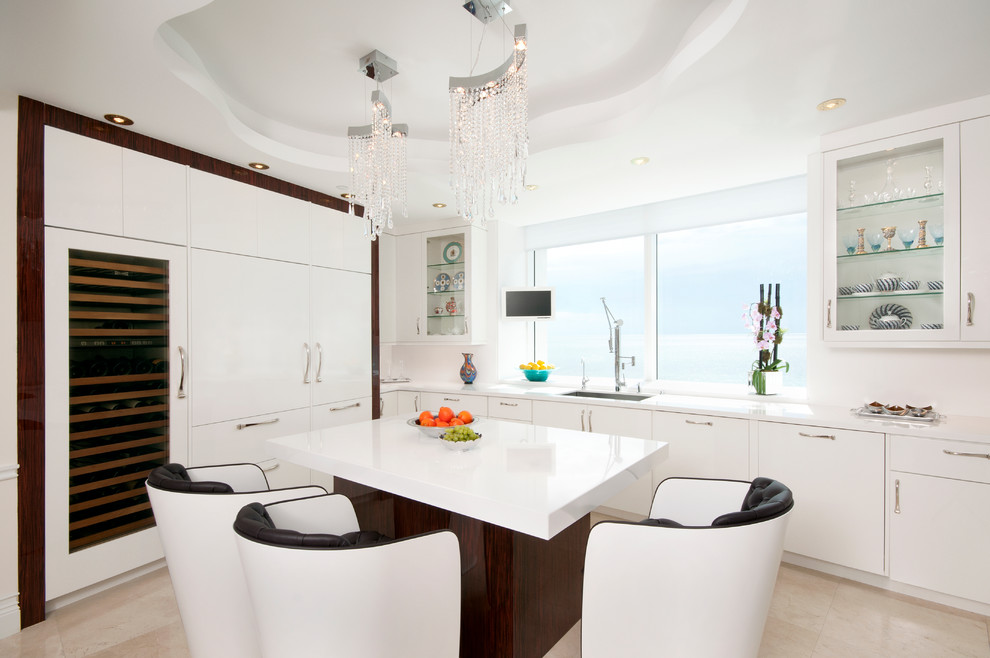 This is an example of a large contemporary u-shaped eat-in kitchen in Miami with an undermount sink, flat-panel cabinets, white cabinets, quartz benchtops, white splashback, stainless steel appliances, marble floors and with island.