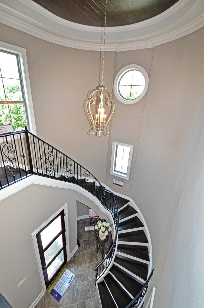 This is an example of a large traditional wood spiral staircase in New Orleans with metal risers.