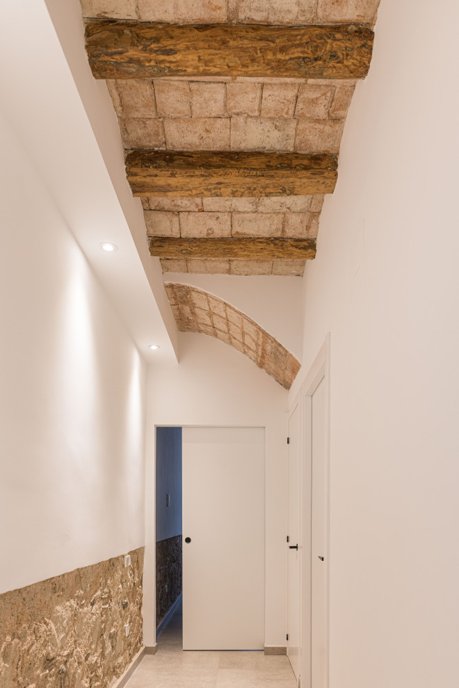 Foto de recibidores y pasillos modernos grandes con paredes blancas, suelo de baldosas de cerámica, suelo beige y vigas vistas