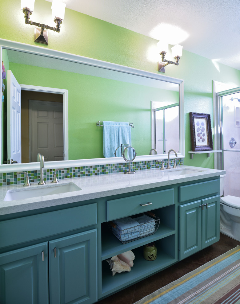 This is an example of a mid-sized traditional 3/4 bathroom in Austin with an undermount sink, raised-panel cabinets, turquoise cabinets, an alcove shower, a two-piece toilet, multi-coloured tile, quartzite benchtops, green walls and concrete floors.