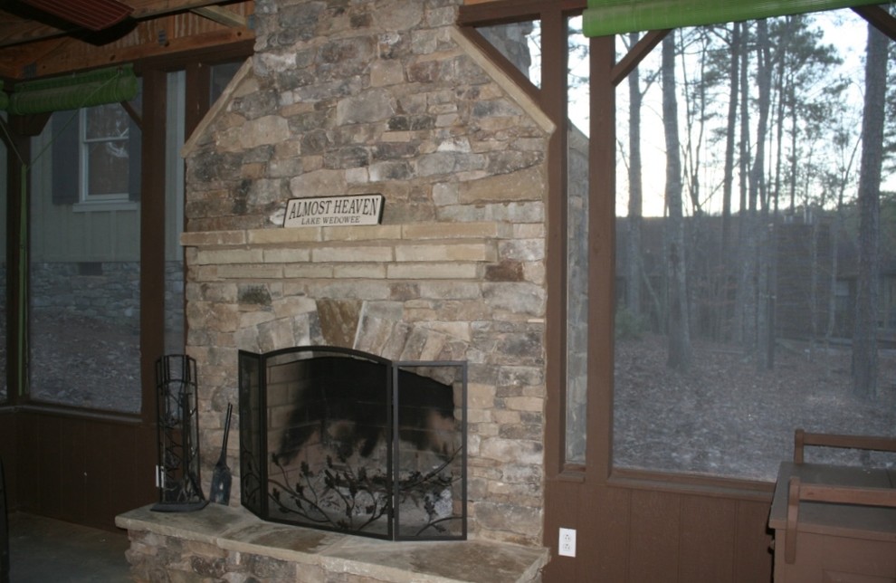 Photo of a mid-sized country sunroom in Atlanta with concrete floors, a standard fireplace, a stone fireplace surround, a standard ceiling and grey floor.