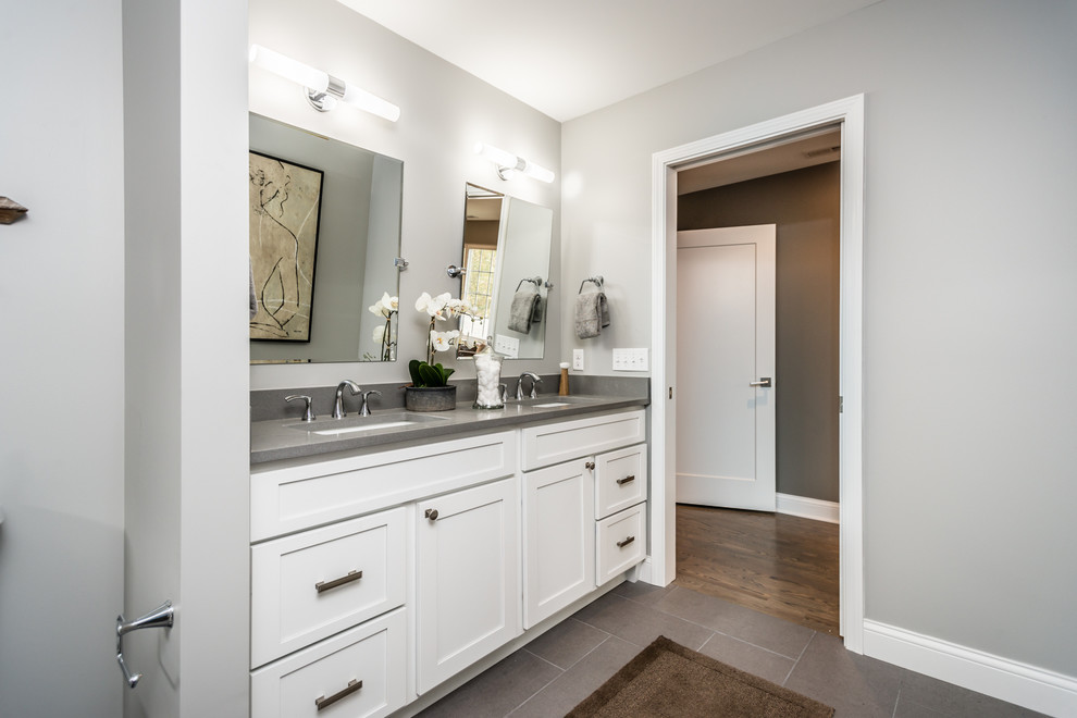Photo of a large contemporary master bathroom in St Louis with recessed-panel cabinets, white cabinets, an open shower, a two-piece toilet, gray tile, ceramic tile, grey walls, ceramic floors, a console sink and granite benchtops.