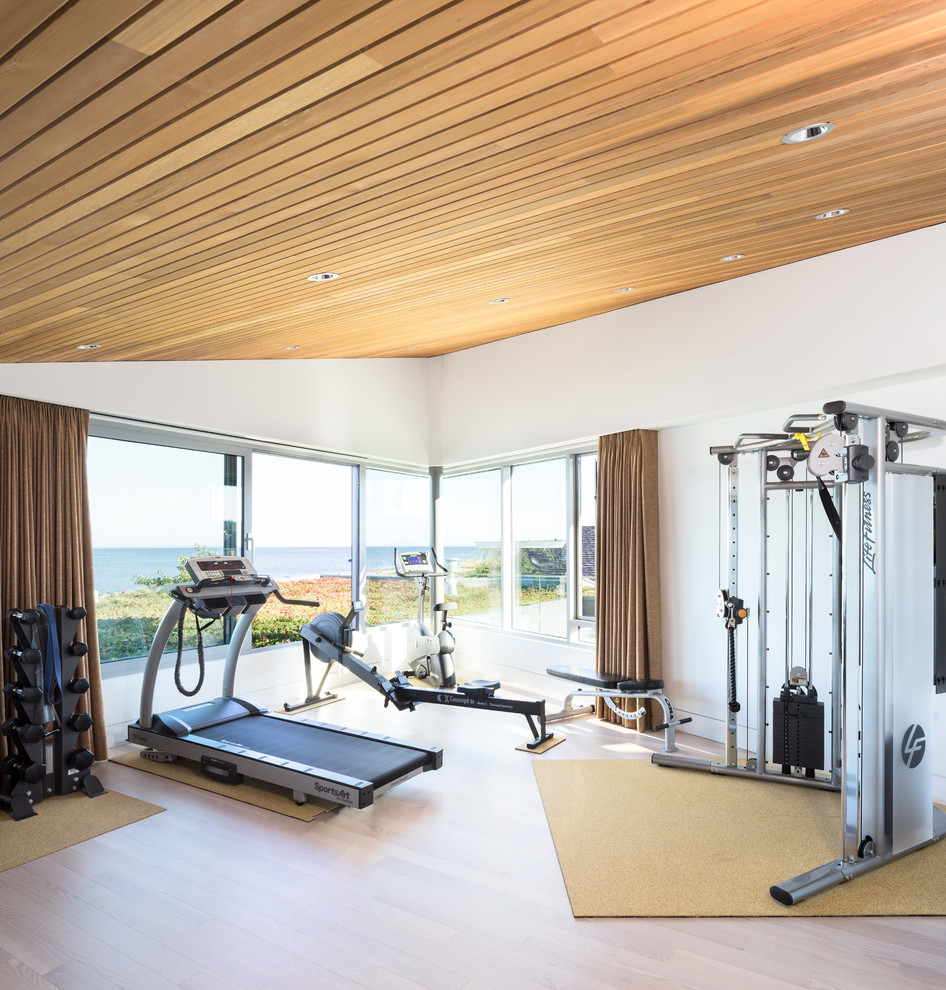 Inspiration for a mid-sized contemporary home weight room in Vancouver with white walls and light hardwood floors.