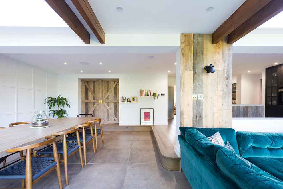 This is an example of a large contemporary open concept living room in Hertfordshire with grey walls, brown floor and ceramic floors.