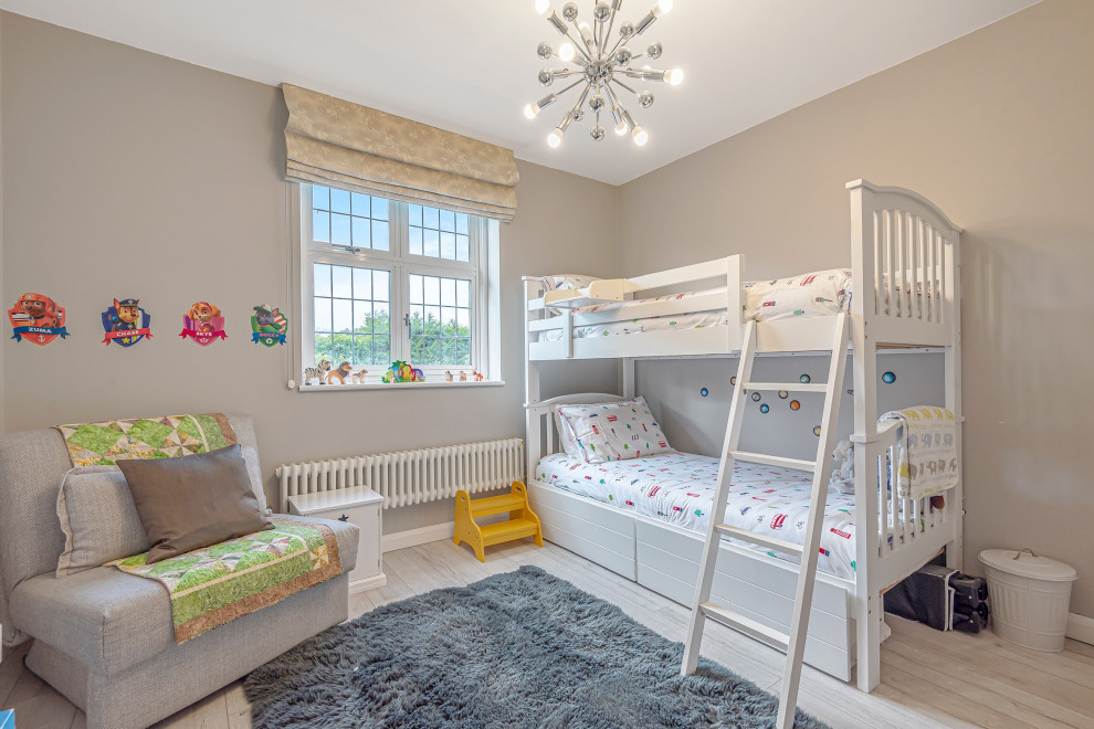 Foto de dormitorio clásico renovado de tamaño medio con paredes grises, suelo de madera clara y suelo gris