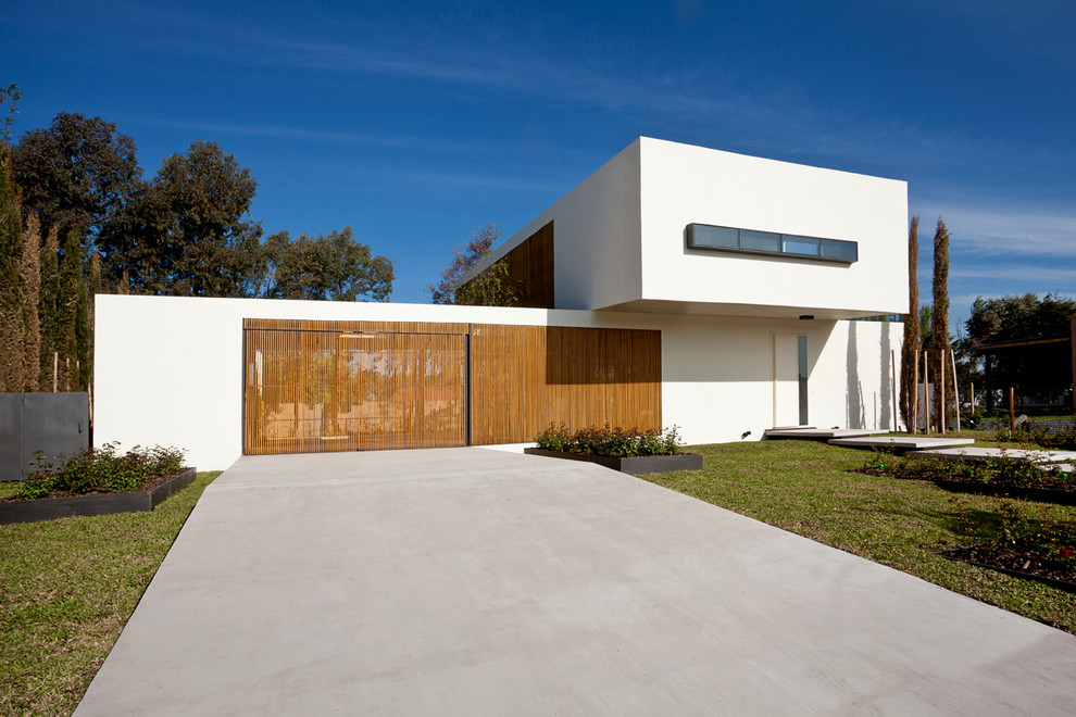 Photo of a modern two-storey stucco white exterior in Other with a flat roof.