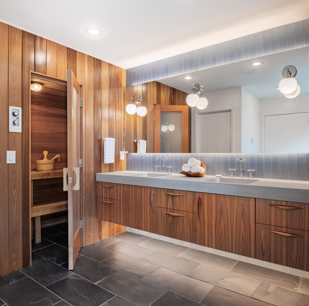 Design ideas for a midcentury ensuite bathroom in Portland with medium wood cabinets, blue tiles, slate flooring, concrete worktops, grey worktops, double sinks, a floating vanity unit, wood walls, flat-panel cabinets, ceramic tiles, an integrated sink, grey floors and an enclosed toilet.