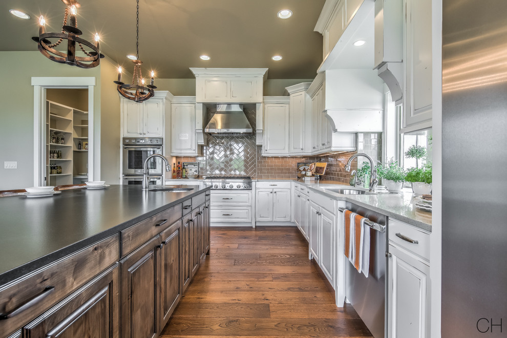 Large transitional l-shaped dark wood floor eat-in kitchen photo in Boise with an undermount sink, raised-panel cabinets, white cabinets, solid surface countertops, beige backsplash, subway tile backsplash, stainless steel appliances and an island