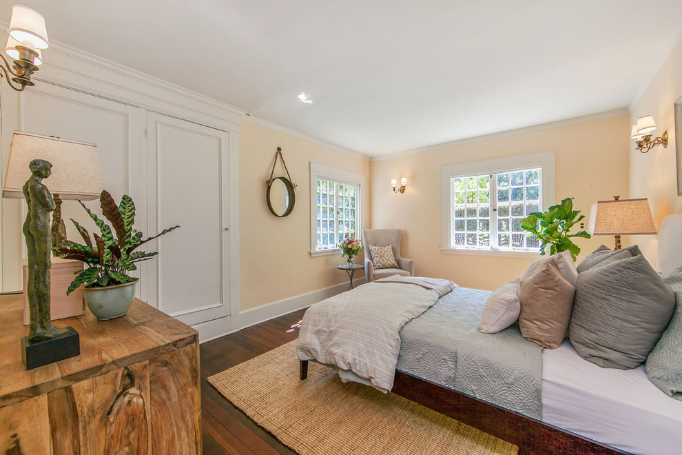 This is an example of a traditional bedroom in San Francisco with beige walls and dark hardwood floors.