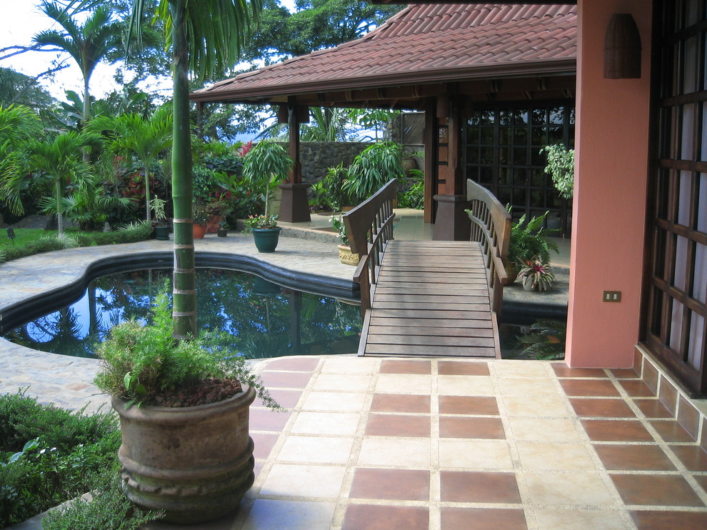 This is an example of a tropical patio in Other with tile.