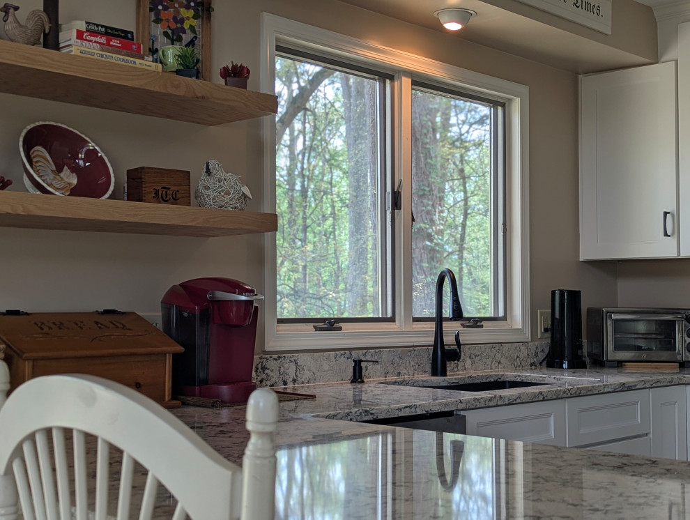 Inspiration for a small transitional u-shaped eat-in kitchen remodel with flat-panel cabinets