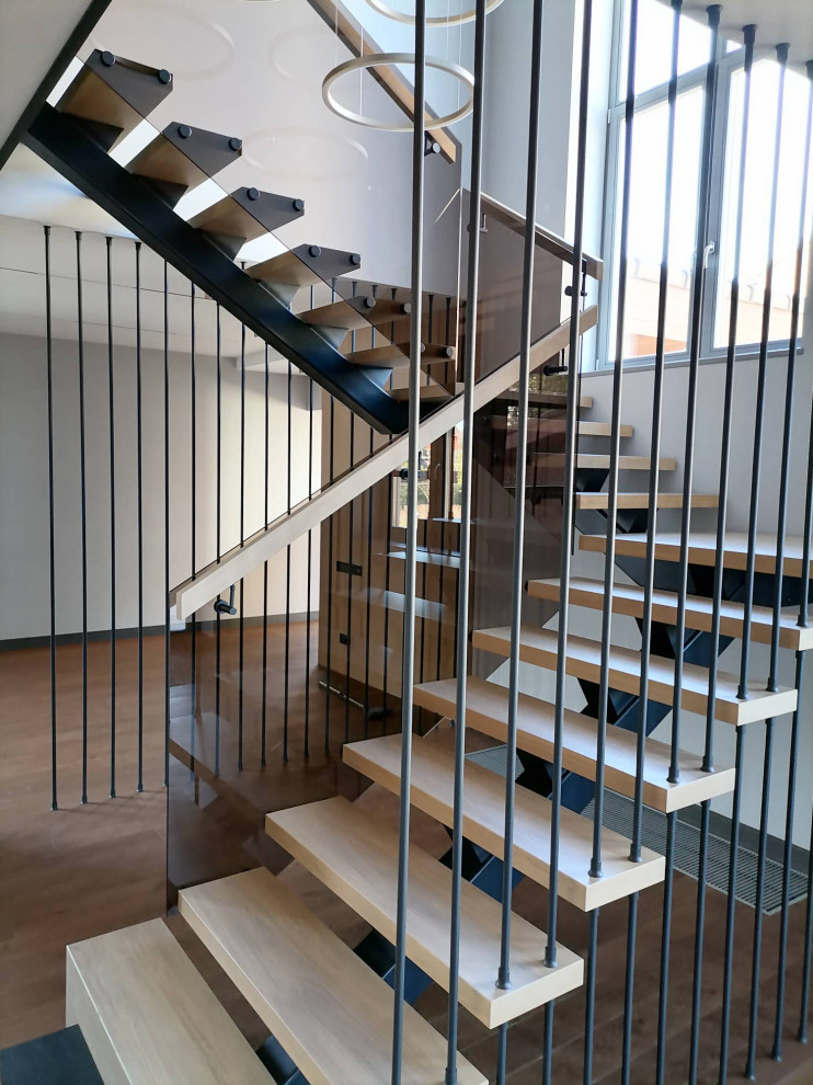 На фото: большая угловая лестница в современном стиле с деревянными ступенями и деревянными перилами с