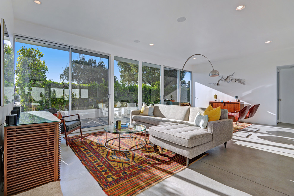 Design ideas for a midcentury living room in Los Angeles with white walls and concrete floors.
