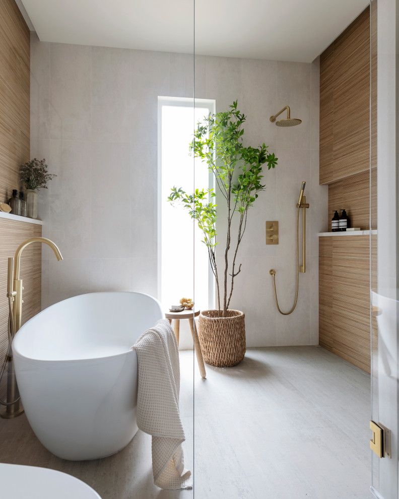 На фото: ванная комната в скандинавском стиле с отдельно стоящей ванной, душевой комнатой, бежевой плиткой, плиткой под дерево, серым полом и душем с распашными дверями с