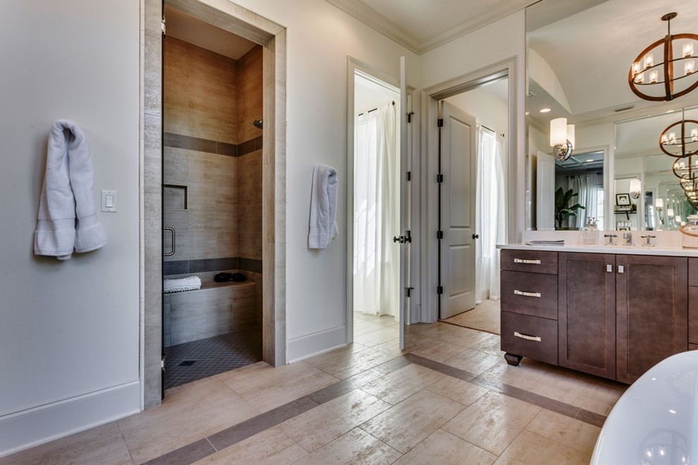 This is an example of a large mediterranean master bathroom in Jacksonville with shaker cabinets, brown cabinets, a freestanding tub, an alcove shower, a two-piece toilet, beige tile, ceramic tile, white walls, ceramic floors, an undermount sink, engineered quartz benchtops, beige floor and a hinged shower door.